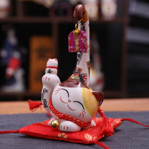 Side view of Japanese style white Lucky Cat with right arm up. It is powered by electricity to make its tails swing, a decoration for indoor.