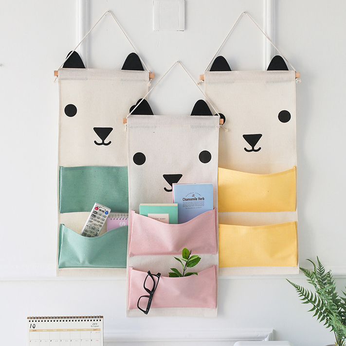 3 cat shaped storage bags hanging on a wall.