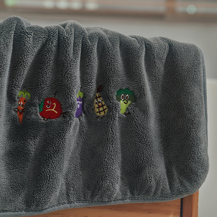 A grey handkerchief with 5 cartoon vegetable characters. Including carrot, tomato, eggplant, corn, and bros.