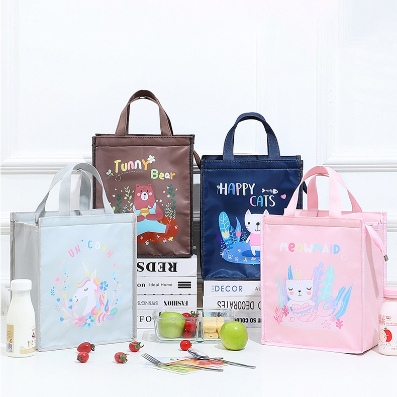 4 cartoon lunch bag. From the left to right, there is a white one with a unicorn, a brown one with a bear, a blue one with a cat, and a pink one with a cat.