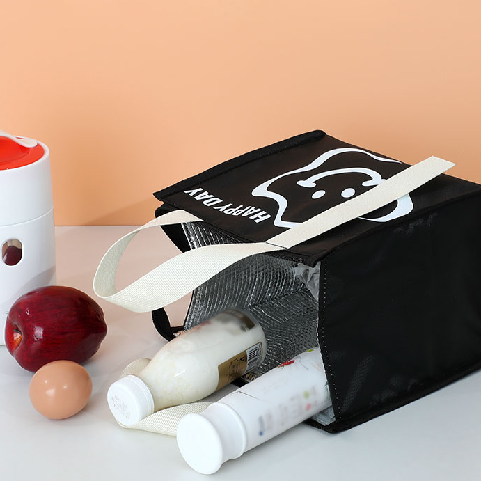 A black and white lunch bag with "Happy Day"Text and a cartoon smiling star.
